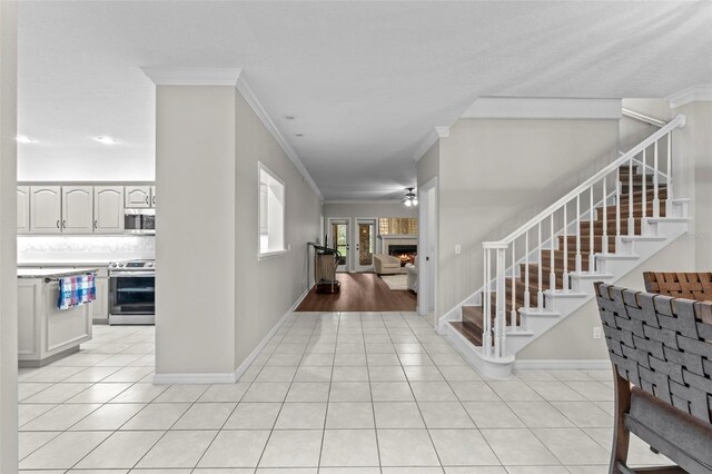 103 Odin Dr, Winter Haven, FL 33884 - foyer with ornamental molding, light tile patterned flooring, stairway, and baseboards