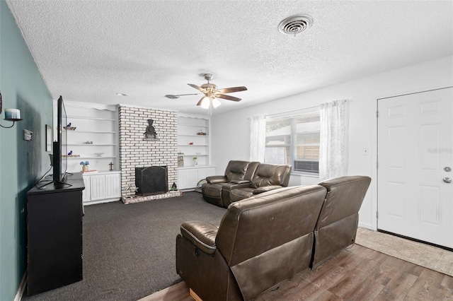 217 Spencer St, Orlando, FL 32839 - living room with a ceiling fan, wood finished floors, a textured ceiling, and a brick fireplace