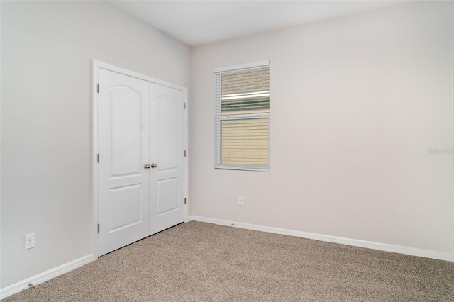 7308 Hermes Ct, Apollo Beach, FL 33572 - unfurnished bedroom with carpet floors, baseboards, and a closet