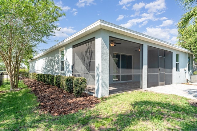 7308 Hermes Ct, Apollo Beach, FL 33572 - view of side of property featuring a sunroom, stucco siding, a patio, and ceiling fan