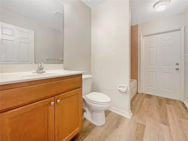 13210 Essman Ave, Port Charlotte, FL 33953 - bathroom featuring wood finished floors, vanity, toilet, and a tub