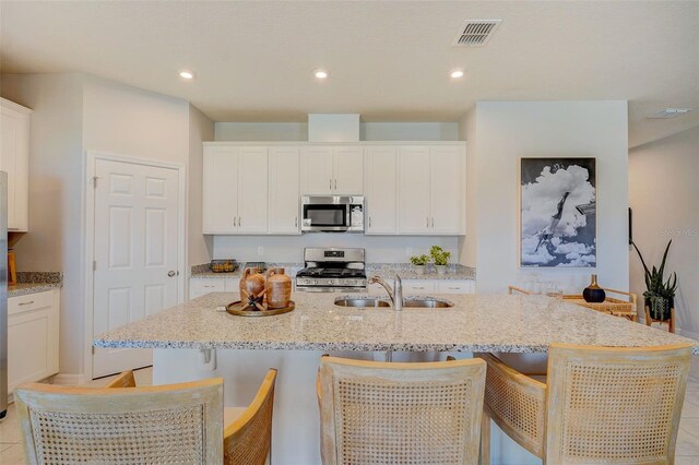 1323 Normandy Dr, Haines City, FL 33844 - kitchen featuring appliances with stainless steel finishes, a sink, white cabinetry, a center island with sink, and recessed lighting