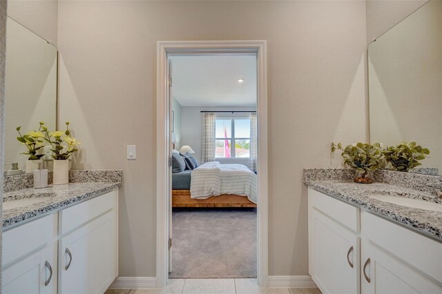1323 Normandy Dr, Haines City, FL 33844 - bathroom featuring two vanities, ensuite bath, baseboards, and tile patterned floors