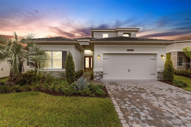 32740 Tree Of Life Ave, Wesley Chapel, FL 33543 - view of front facade featuring stone siding, decorative driveway, a garage, and stucco siding