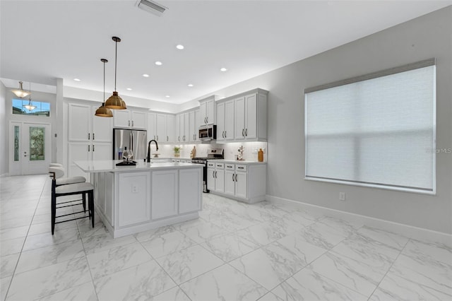 32740 Tree Of Life Ave, Wesley Chapel, FL 33543 - kitchen with stainless steel appliances, light marble finish floors, light countertops, and recessed lighting