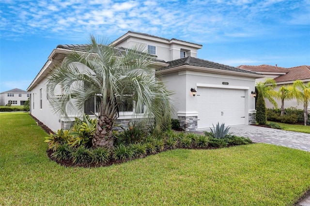 32740 Tree Of Life Ave, Wesley Chapel, FL 33543 - view of front of house featuring decorative driveway, stucco siding, a front yard, a garage, and stone siding