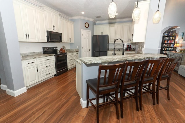 319 Morning View Dr, Winter Garden, FL 34787 - kitchen with black appliances, a peninsula, dark wood-style floors, arched walkways, and white cabinetry