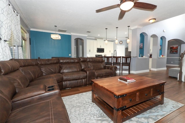 319 Morning View Dr, Winter Garden, FL 34787 - living room featuring ceiling fan, wood finished floors, crown molding, and arched walkways