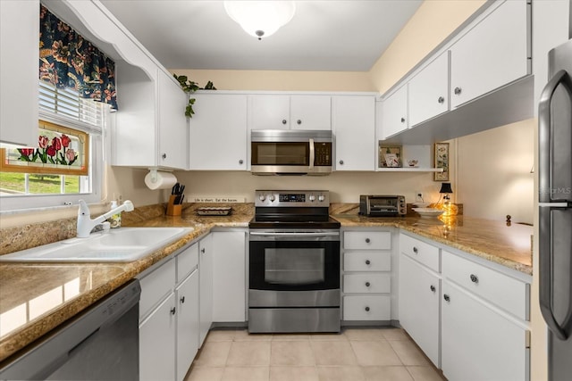 1146 Villa Ln Unit 101, Apopka, FL 32712 - kitchen with appliances with stainless steel finishes, a sink, white cabinets, and light tile patterned floors