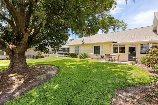 1146 Villa Ln Unit 101, Apopka, FL 32712 - rear view of property featuring a yard, a patio, and a shingled roof