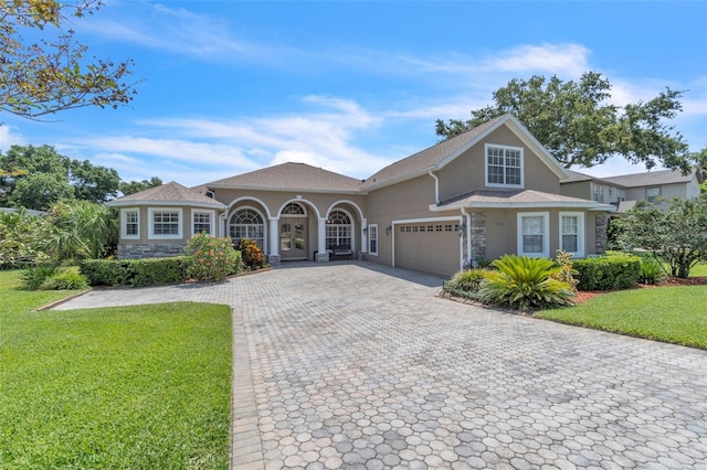 1017 Parkside Pointe Blvd, Apopka, FL 32712 - view of front of home with a front lawn, an attached garage, decorative driveway, and stucco siding