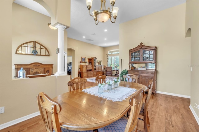 1017 Parkside Pointe Blvd, Apopka, FL 32712 - dining area with arched walkways, decorative columns, light wood-type flooring, baseboards, and a chandelier