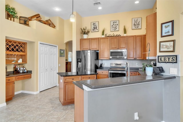 1017 Parkside Pointe Blvd, Apopka, FL 32712 - kitchen with appliances with stainless steel finishes, a peninsula, dark countertops, arched walkways, and a towering ceiling