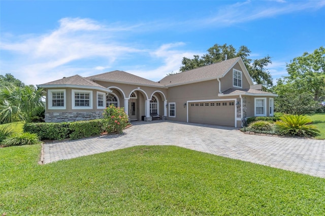 1017 Parkside Pointe Blvd, Apopka, FL 32712 - mediterranean / spanish home featuring a front lawn, stucco siding, decorative driveway, and a garage