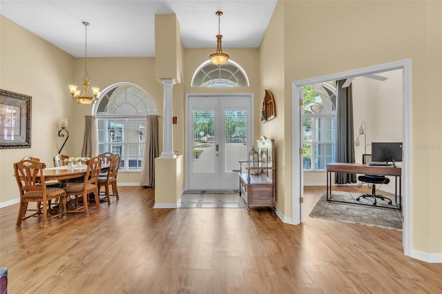 1017 Parkside Pointe Blvd, Apopka, FL 32712 - entryway featuring wood finished floors, a high ceiling, baseboards, a chandelier, and decorative columns