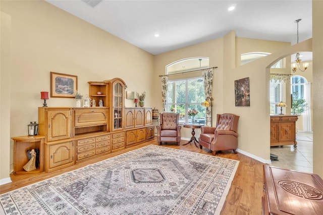 1017 Parkside Pointe Blvd, Apopka, FL 32712 - living area featuring arched walkways, baseboards, light wood finished floors, recessed lighting, and a towering ceiling