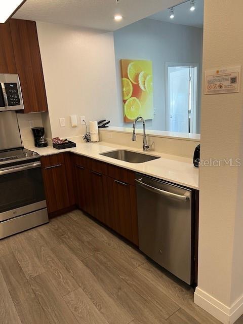 14501 Grove Resort Ave Unit 2129, Winter Garden, FL 34787 - kitchen with appliances with stainless steel finishes, a sink, light wood finished floors, and light countertops