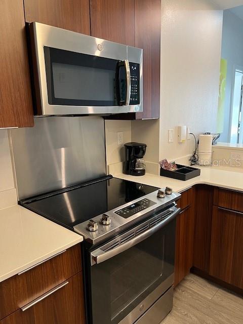 14501 Grove Resort Ave Unit 2129, Winter Garden, FL 34787 - kitchen with appliances with stainless steel finishes, light countertops, light wood finished floors, and modern cabinets