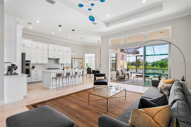 4754 Manning Ct, Sarasota, FL 34240 - living room featuring recessed lighting, light wood-style floors, a water view, and crown molding
