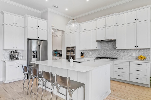 4754 Manning Ct, Sarasota, FL 34240 - kitchen with appliances with stainless steel finishes, a sink, a center island with sink, tasteful backsplash, and a kitchen breakfast bar