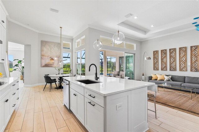 4754 Manning Ct, Sarasota, FL 34240 - kitchen featuring a sink, light wood-style floors, light countertops, white cabinetry, and crown molding
