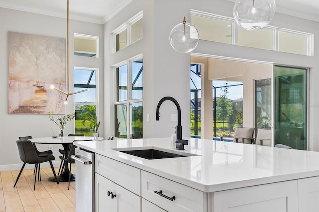 4754 Manning Ct, Sarasota, FL 34240 - kitchen featuring a sink, crown molding, healthy amount of natural light, light countertops, and white cabinets