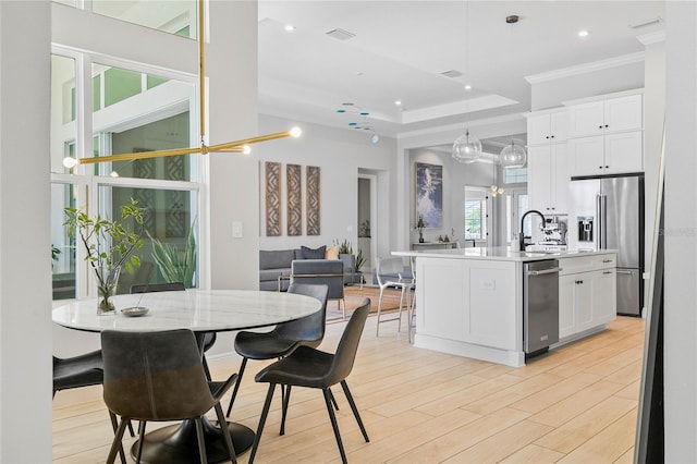 4754 Manning Ct, Sarasota, FL 34240 - dining space with crown molding, light wood-style flooring, recessed lighting, and a raised ceiling