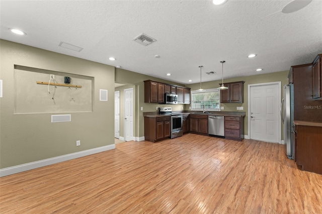17 S Aurora Dr, Apopka, FL 32703 - kitchen featuring stainless steel appliances, light wood-style floors, baseboards, a textured ceiling, and recessed lighting