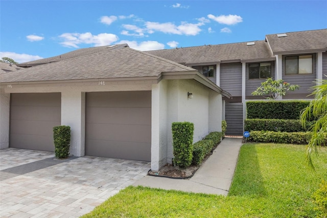 148 Olive Tree Cir Unit 148, Altamonte Springs, FL 32714 - view of property exterior featuring a shingled roof, stucco siding, a lawn, an attached garage, and driveway