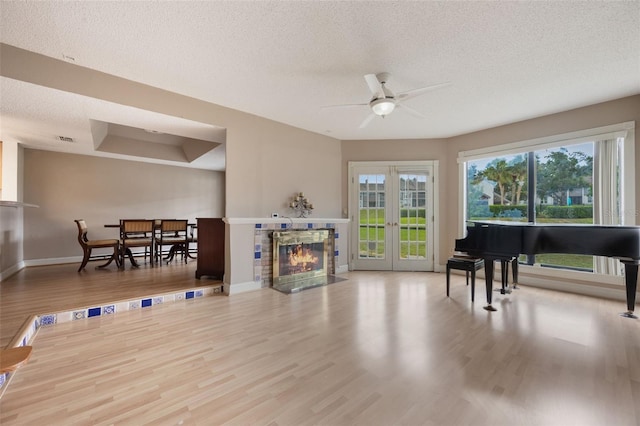 148 Olive Tree Cir Unit 148, Altamonte Springs, FL 32714 - living room featuring ceiling fan, a textured ceiling, baseboards, wood finished floors, and a fireplace with flush hearth