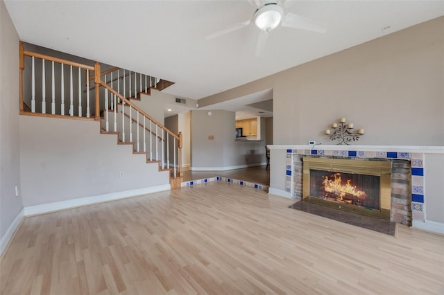 148 Olive Tree Cir Unit 148, Altamonte Springs, FL 32714 - unfurnished living room featuring wood finished floors, ceiling fan, a fireplace with flush hearth, stairway, and baseboards