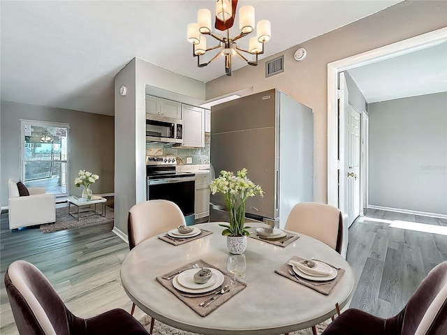 6100 12th St S Unit 313, Saint Petersburg, FL 33705 - dining room featuring wood finished floors, a chandelier, and baseboards