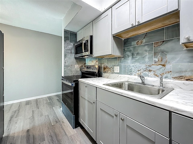 6100 12th St S Unit 313, Saint Petersburg, FL 33705 - kitchen featuring stainless steel microwave, black / electric stove, a sink, and tasteful backsplash