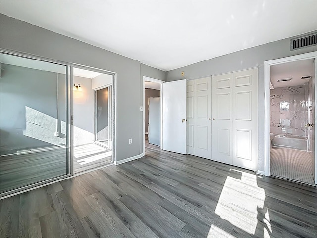 6100 12th St S Unit 313, Saint Petersburg, FL 33705 - unfurnished bedroom with wood finished floors, a closet, baseboards, and ensuite bathroom