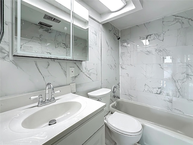 6100 12th St S Unit 313, Saint Petersburg, FL 33705 - bathroom featuring vanity, washtub / shower combination, toilet, and tile walls