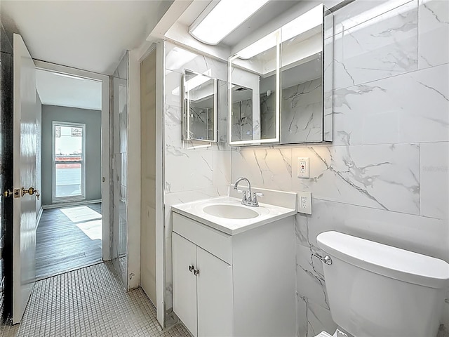 6100 12th St S Unit 313, Saint Petersburg, FL 33705 - bathroom featuring toilet, vanity, tile walls, and tile patterned floors