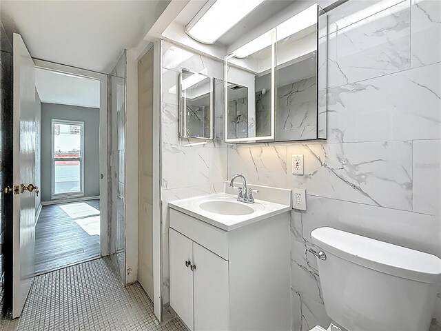 6100 12th St S Unit 313, Saint Petersburg, FL 33705 - bathroom with toilet, vanity, tile walls, and tile patterned flooring