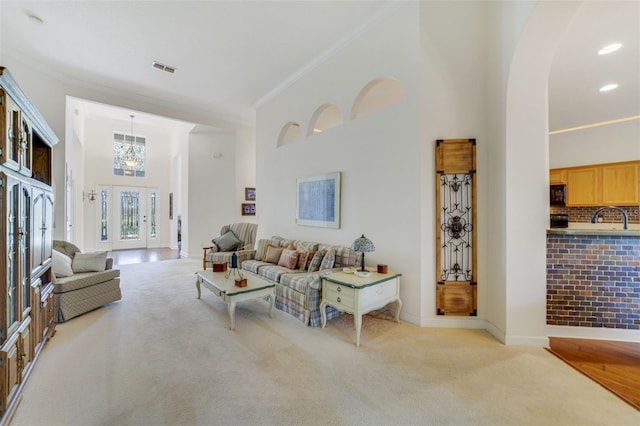 1515 Cherry Lake Way, Lake Mary, FL 32746 - living area featuring crown molding, light colored carpet, a high ceiling, a chandelier, and baseboards