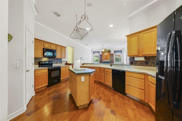 1515 Cherry Lake Way, Lake Mary, FL 32746 - kitchen with black appliances, ornamental molding, decorative backsplash, a peninsula, and dark wood-type flooring