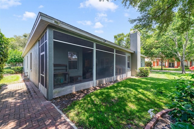 1515 Cherry Lake Way, Lake Mary, FL 32746 - view of side of property with a sunroom, a chimney, a lawn, and stucco siding