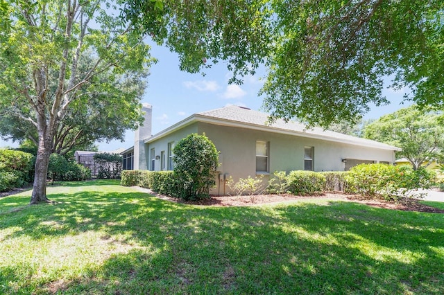 1515 Cherry Lake Way, Lake Mary, FL 32746 - view of side of property with stucco siding, a lawn, an attached garage, and a chimney