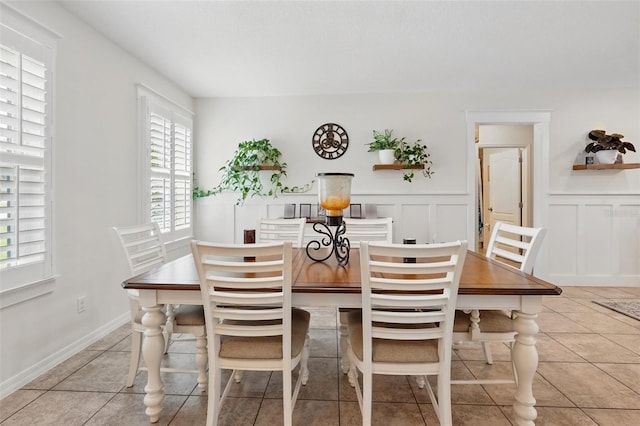 15411 Taurus Ct, Mascotte, FL 34753 - dining area with light tile patterned flooring, a decorative wall, and a wainscoted wall