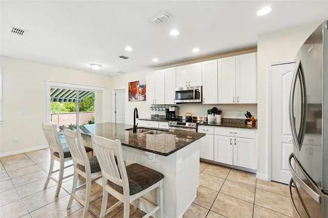 15411 Taurus Ct, Mascotte, FL 34753 - kitchen with stainless steel appliances, a sink, light tile patterned floors, recessed lighting, and a kitchen breakfast bar