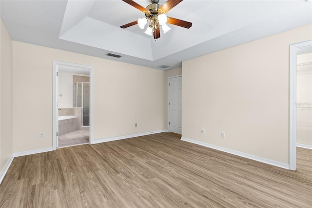 1062 Wickerwood St, Ocoee, FL 34761 - unfurnished bedroom with light wood-style flooring, a raised ceiling, and baseboards
