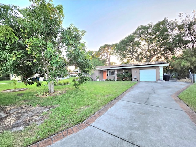 663 68th Ave S, Saint Petersburg, FL 33705 - view of front facade with driveway, an attached garage, a front yard, and stucco siding