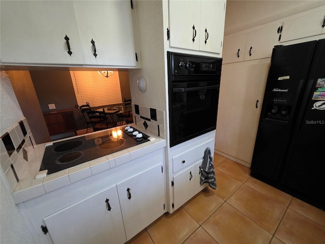 663 68th Ave S, Saint Petersburg, FL 33705 - kitchen with black appliances, tile countertops, and white cabinetry