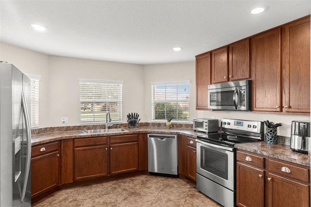 1805 Kingsmill Dr, Bartow, FL 33830 - kitchen featuring stainless steel appliances, a sink, dark countertops, recessed lighting, and brown cabinetry