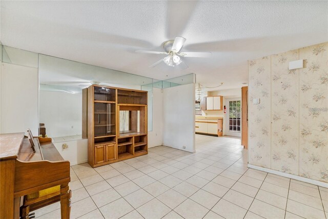 7024 Harwick Dr, Orlando, FL 32818 - unfurnished room with a ceiling fan, a textured ceiling, wallpapered walls, light tile patterned flooring, and baseboards