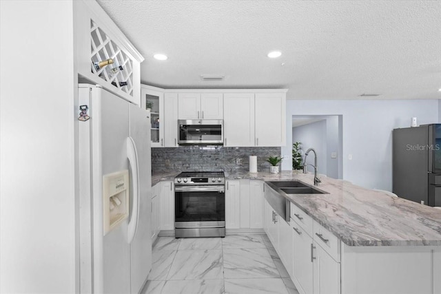 14506 Sutter Pl, Tampa, FL 33625 - kitchen featuring stainless steel appliances, a sink, a peninsula, recessed lighting, and light marble finish floors