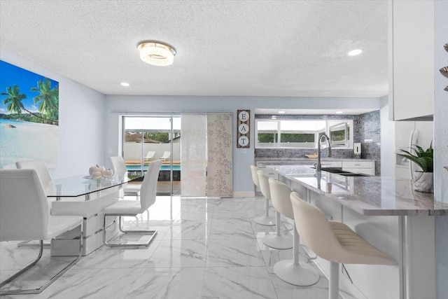14506 Sutter Pl, Tampa, FL 33625 - dining room with a textured ceiling, light marble finish flooring, and recessed lighting